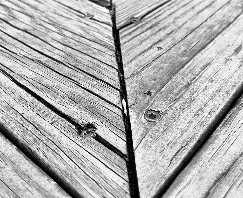 Close-up of cracked, weathered gray deck boards