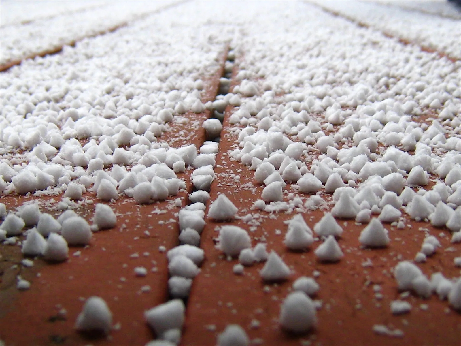 Snow pellets collecting on reddish deck boards